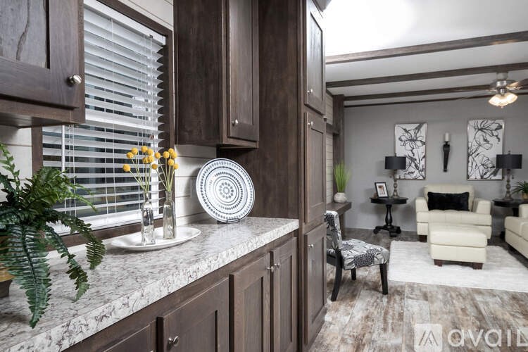 A kitchen with dark wood cabinets and a marble countertop.