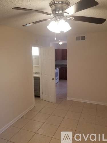 A room with a ceiling fan and a light fixture.