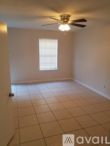 A room with a ceiling fan and a window.
