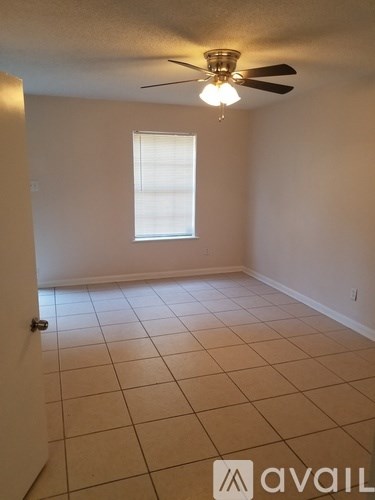 A room with a ceiling fan and a window.
