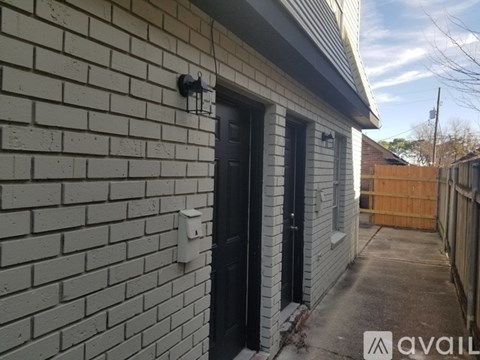 A house with a black door and a white wall.