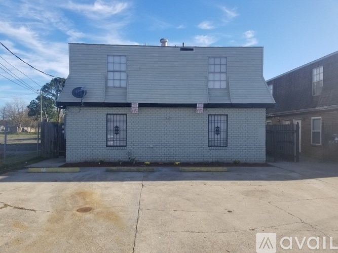 A white house with a black gate in front.