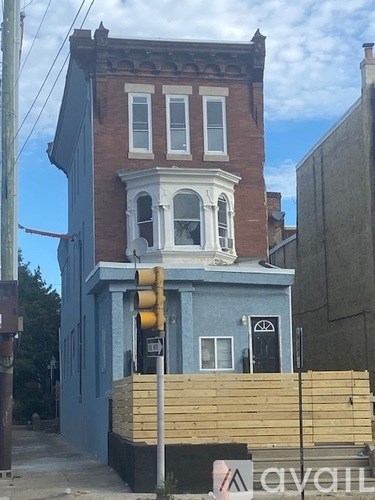 A blue building with a red awning and a yellow traffic light.