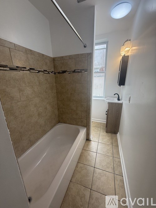 A bathroom with a tiled shower and bathtub.