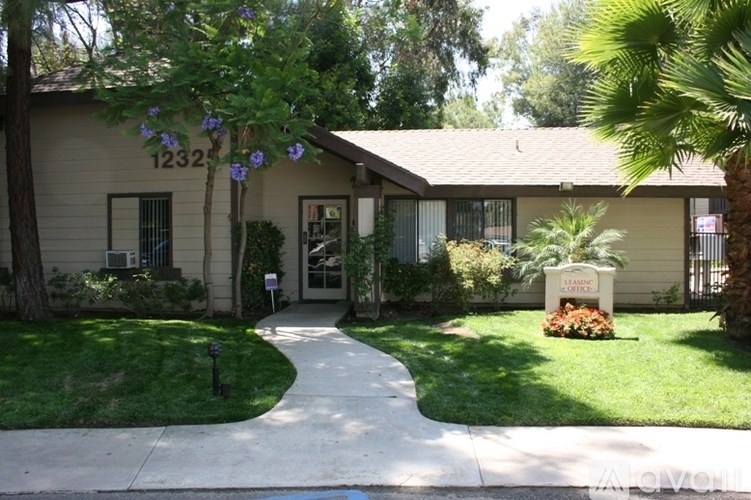 A house numbered 1232 with a white fence and a green lawn.