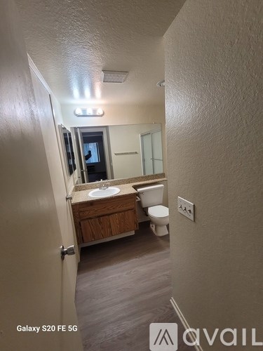 A bathroom with a toilet, sink, and mirror.