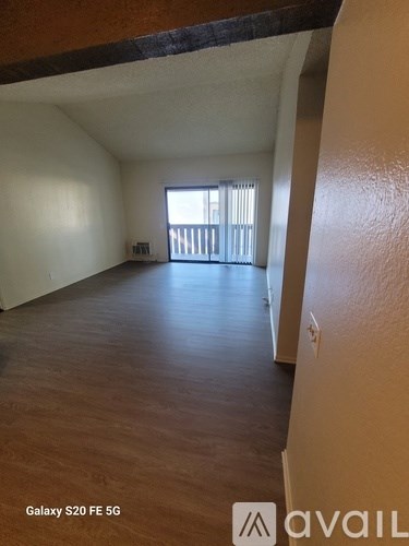 A room with a window and a door leading to a balcony.
