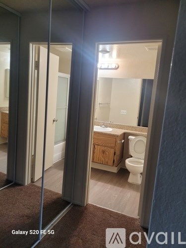 A bathroom with a toilet, sink, and mirror.