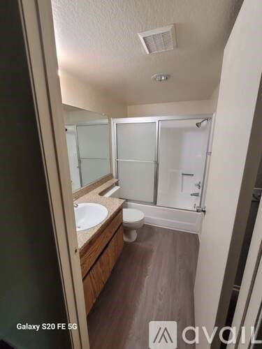 A bathroom with a toilet, sink, and shower.