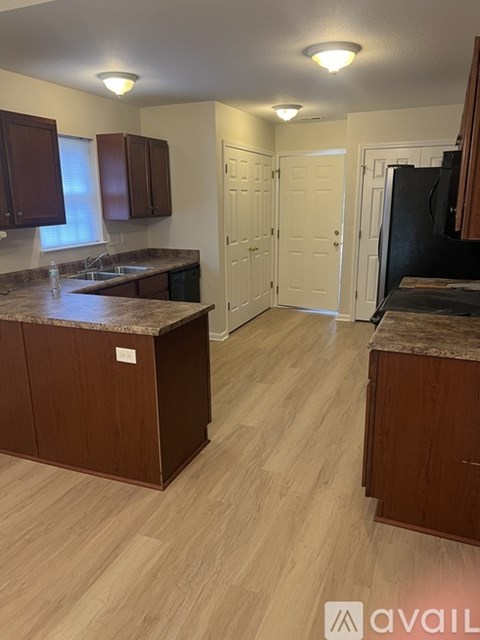 A kitchen with brown cabinets and a granite countertop.