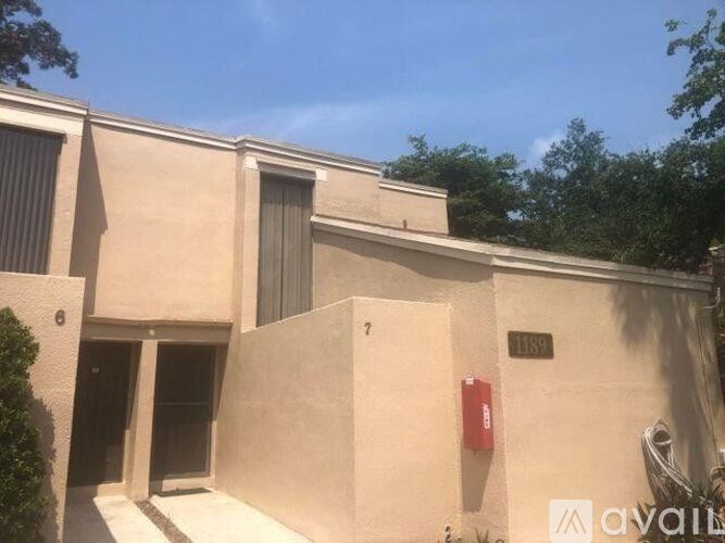 A modern building with a beige facade and a red fire extinguisher on the wall.