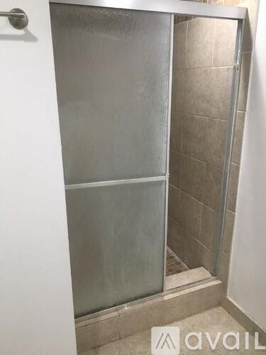 A shower stall with a glass door is in a bathroom.