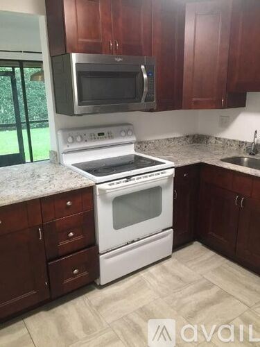 A kitchen with a white stove and microwave above it.