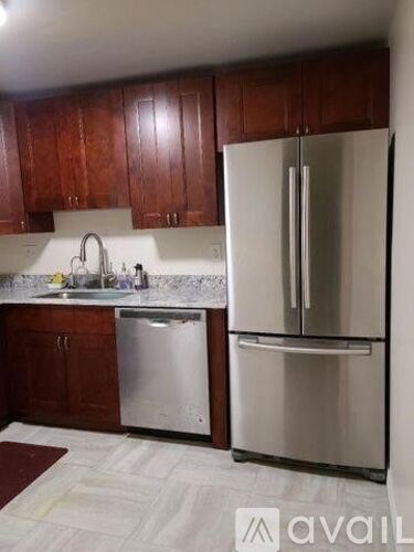 A kitchen with a white fridge and a white sink.