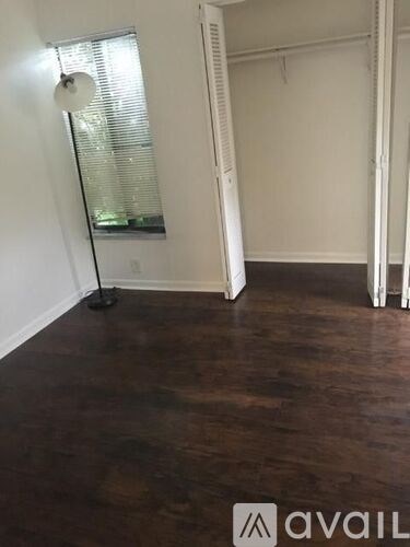 A room with a dark wooden floor and white walls.