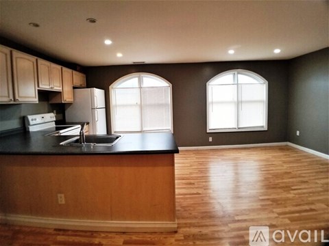 A kitchen with wooden cabinets and a black countertop.