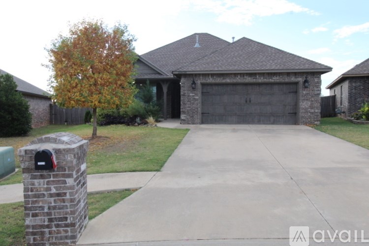 A house with a brick pillar and mailbox in front.