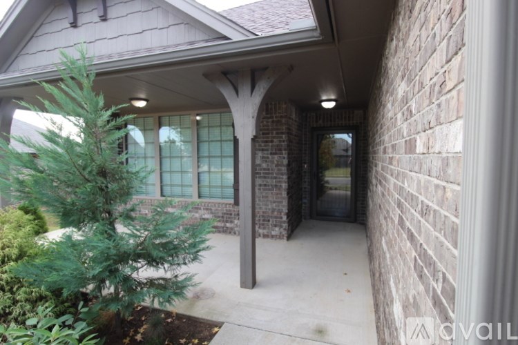 A house with a covered patio and a tree.