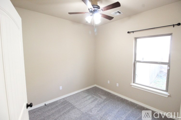 A room with a ceiling fan and a window.