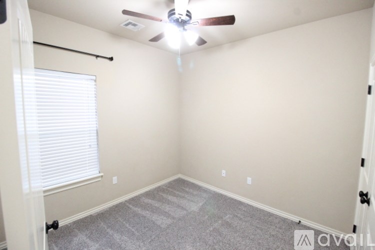 A room with a ceiling fan and carpeted floor.