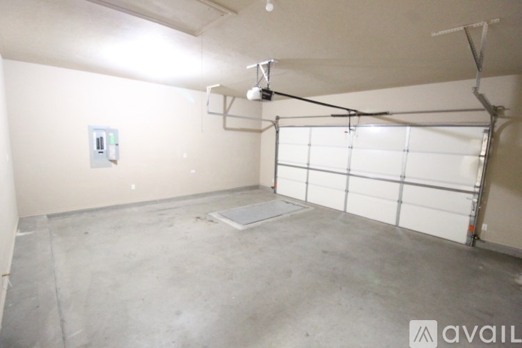 A spacious garage with a white door and a grey floor.