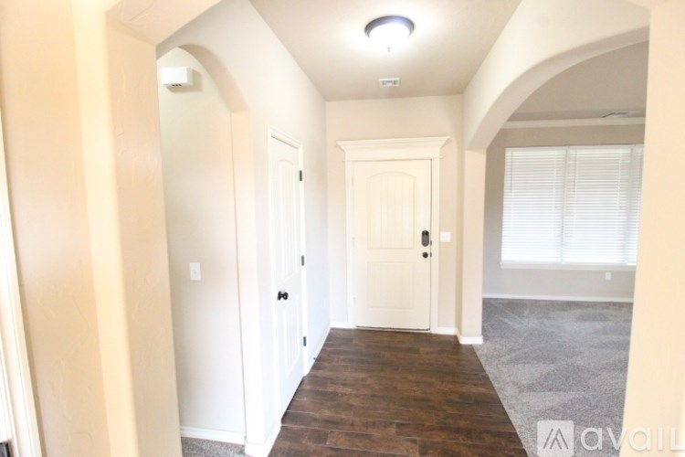 A hallway with white doors and a wooden floor.