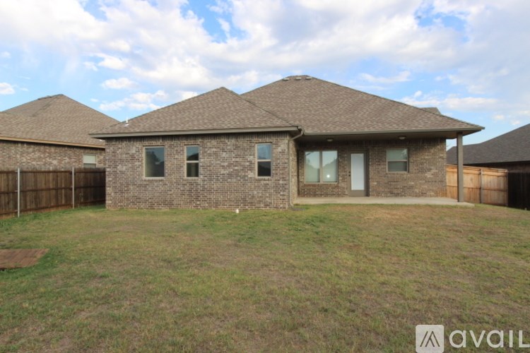 A house with a brown roof and a fence in front of it.