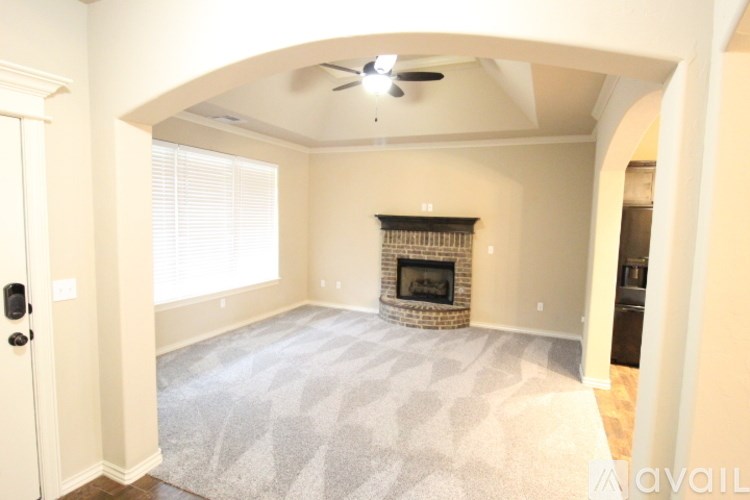 A living room with a fireplace and a rug.