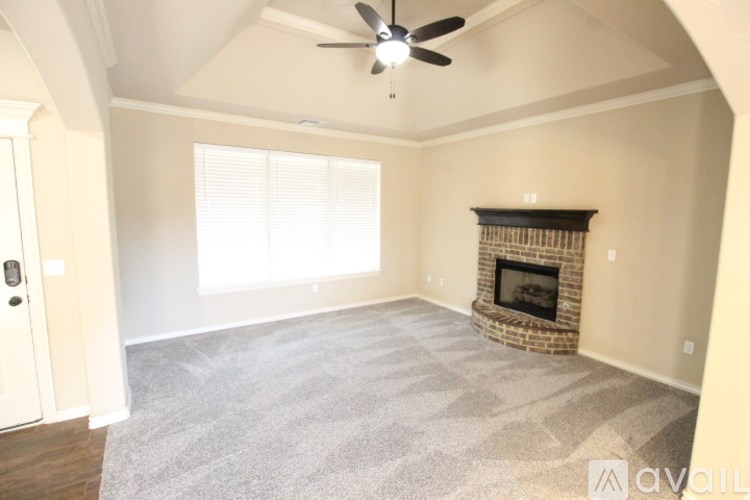 A living room with a fireplace and a ceiling fan.