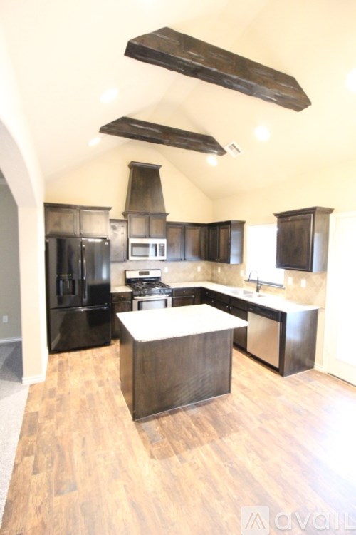 A modern kitchen with dark wood cabinets and a large island.