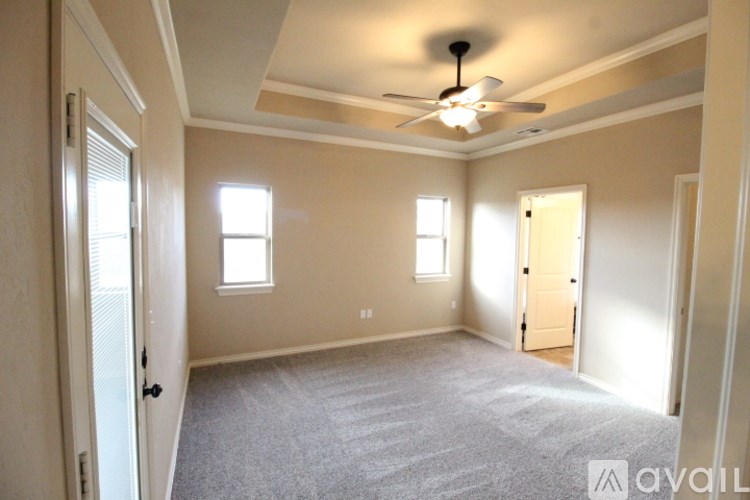 A room with a ceiling fan and carpeted floor.
