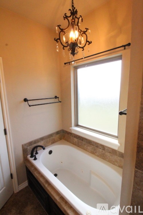 A bathroom with a tub and a chandelier.