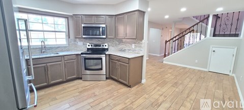 A kitchen with wooden floors and a stove top oven.