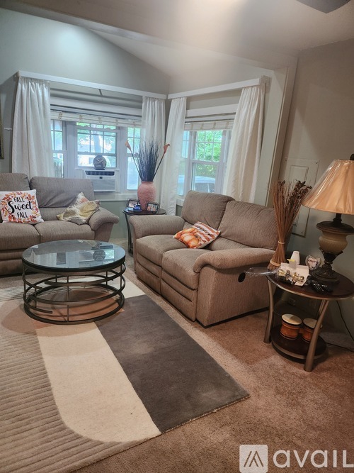 A living room with a glass coffee table and a beige sofa.