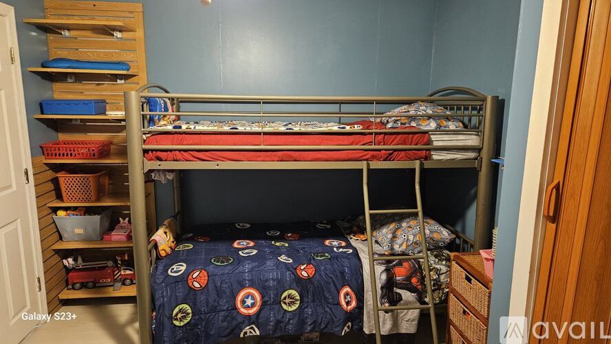 A bedroom with a bunk bed and a ladder.