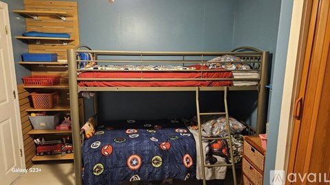 A bedroom with a bunk bed and a ladder.