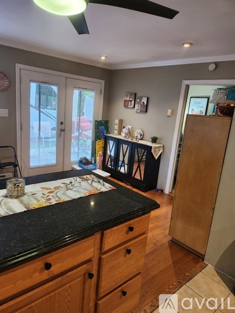 A kitchen with wooden cabinets and a black countertop.
