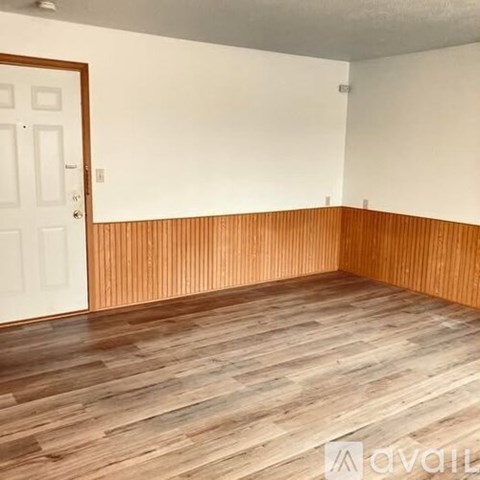 A room with wooden flooring and a white door.