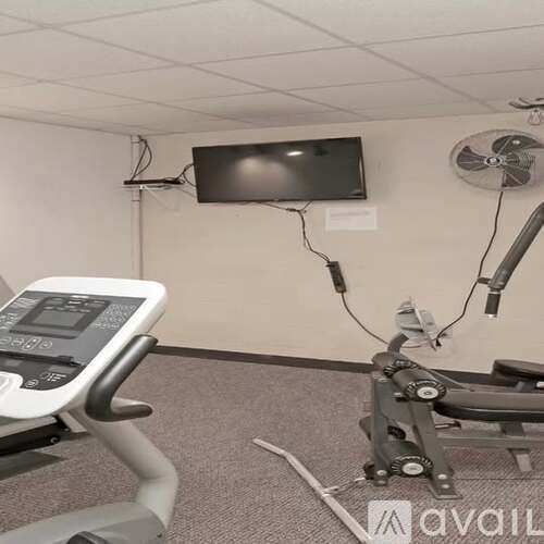 A treadmill and a television are in a room.