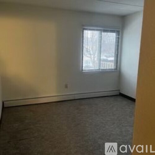 A room with a window and carpeted floor.