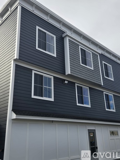 A two-story house with a grey facade and white trim.