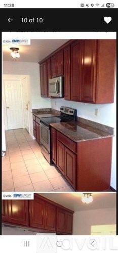 A kitchen with brown cabinets and a white wall.