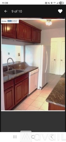 A kitchen with brown cabinets and a white refrigerator.