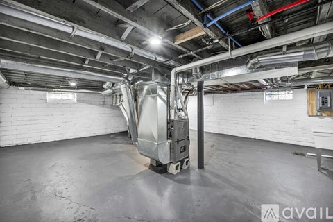 A large industrial air handling unit in a spacious room with exposed ductwork.