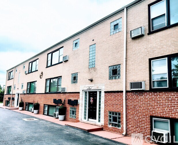 A red brick building with a black door and windows.