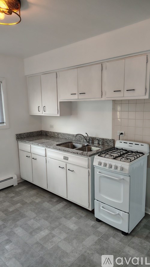 A kitchen with white appliances and cabinets.