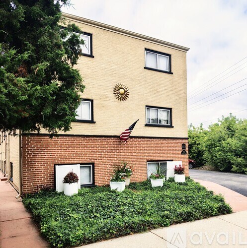 A brick building with a sun design on the wall and an American flag.