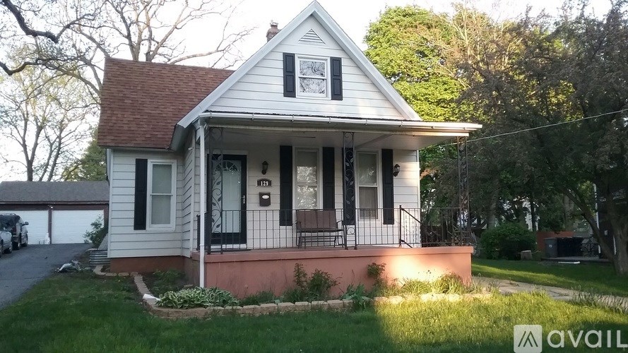 A house with a porch and a sign that says "available" in the front yard.