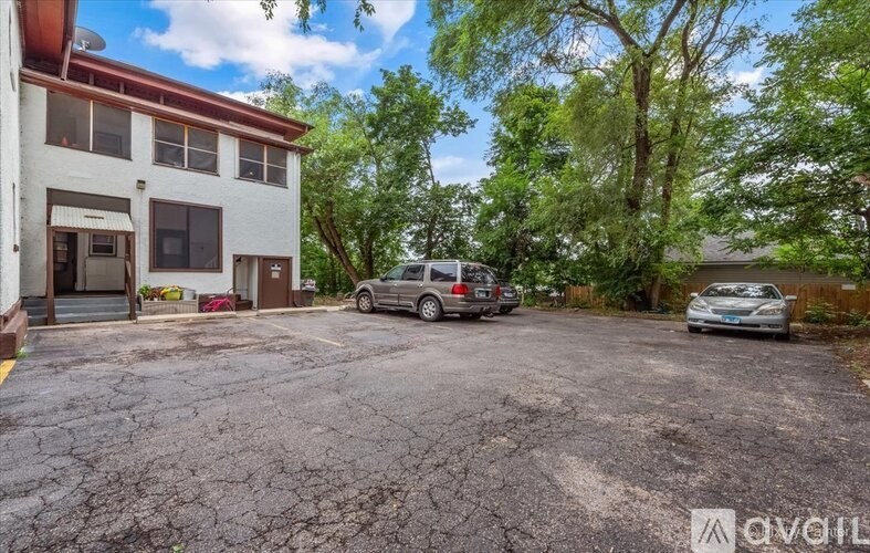 A parking lot with a building and two cars.
