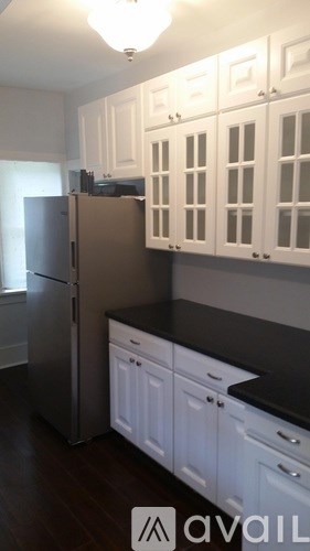 A kitchen with white cabinets and a black countertop.